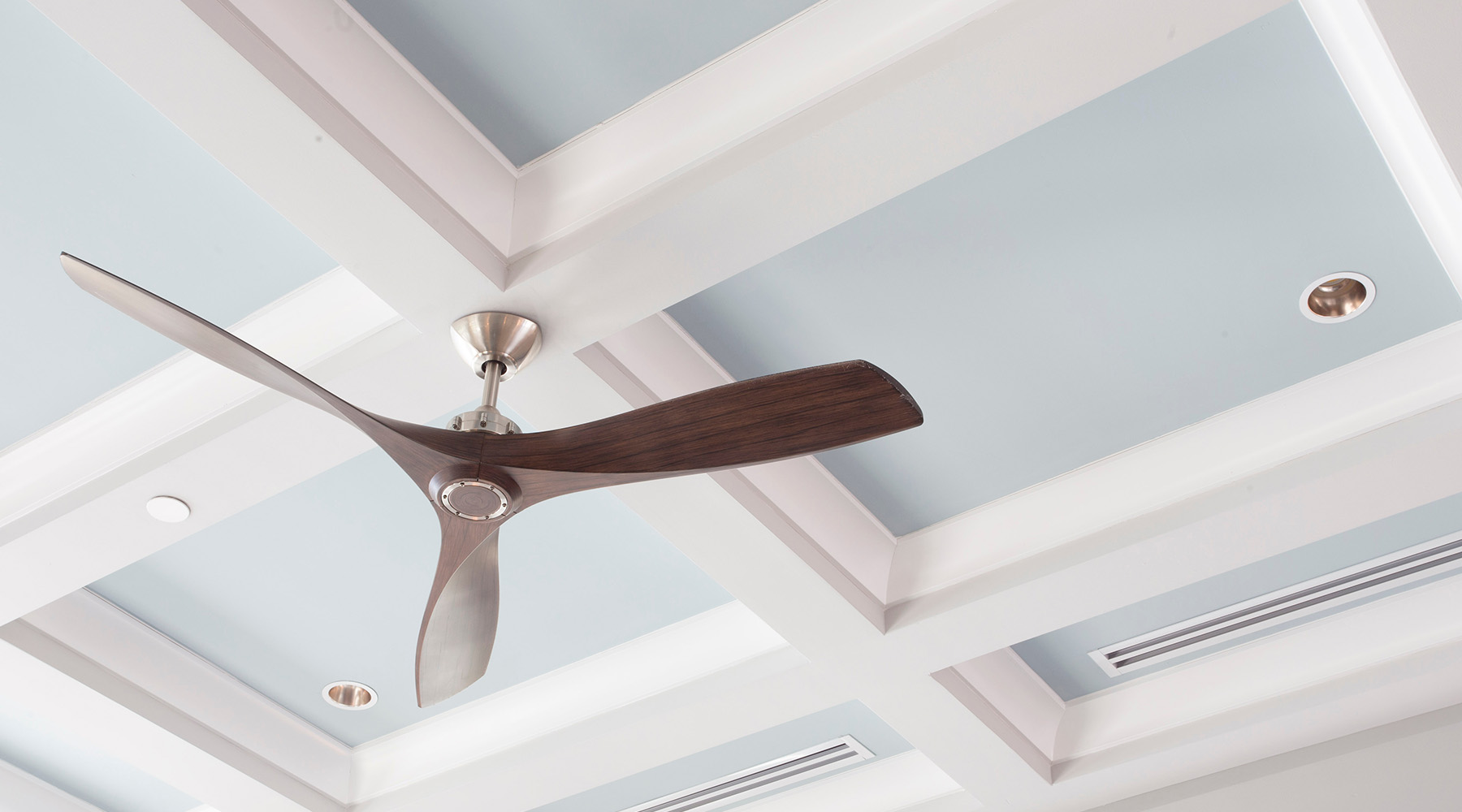 Elegant coffered ceiling adorned with geometric patterns, featuring a modern ceiling fan as a stylish and functional centerpiece